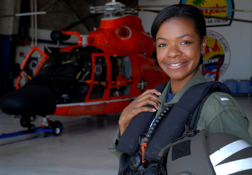 Lt. j.g. La'Shanda Holmes stands in front of an MH-65 Dolphin helicopter at Air Station Los Angeles. U.S. Coast Guard - Photograph by Petty Officer 1st Class Adam Eggers