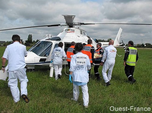 Alors que le médecin fait état de son diagnostic par téléphone, le personnel médical se dirige vers l'hélicoptère pour y installer la victime - Photo Ouest-France