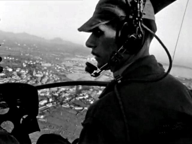 Pilote aux commandes d'un Piasecki HUP 2 survolant le paysage - Photo DR INA