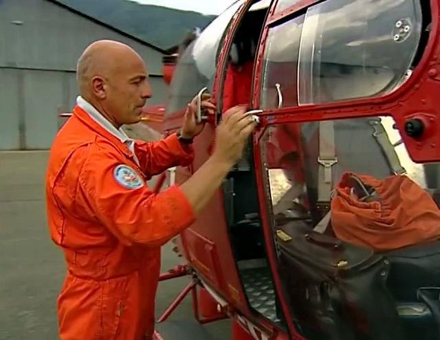 Francis Delafosse referme pour la dernière fois la porte latérale de l'Alouette 3 SA-316B immatriculée F-ZBFM, indicatif Dragon 38 - Photo extraite du reportage Le MAG “C'était le temps du secours rouge” - Septembre 2005 © France 3 Alpes