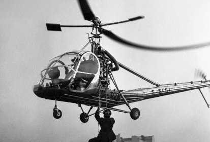 Frédéric Curie monte à l'échelle sous le Hiller 360 F-BFGZ, à (...)