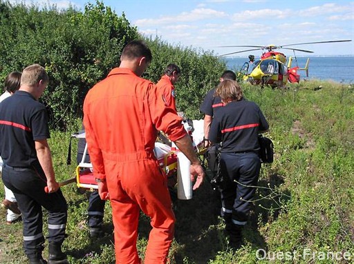 Les sapeurs-pompiers et les hommes de la sécurité civile ramènent le patient sur sa civière, à l'hélicoptère. Le pilote est affranchi de toute autorisation pour se poser.
